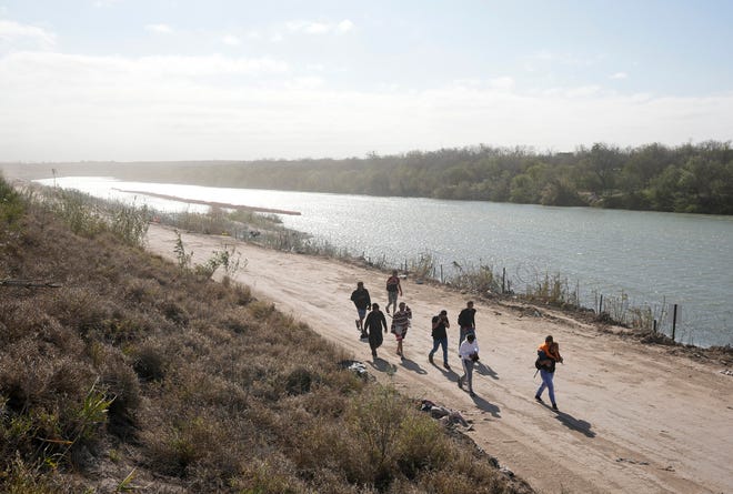 A group of migrants from Venezuela walk along the banks of the Rio Grande to surrender to U.S. Border Patrol after they entered Texas at Eagle Pass on Monday January 8, 2024.